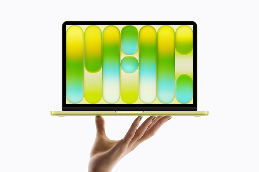 MacBook Neo en color citrus sostenido en la mano