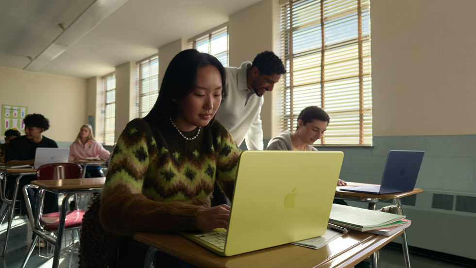 Estudiante con MacBook Neo en color citrus en un aula