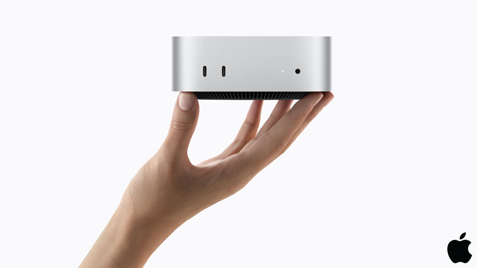 Nueva Mac mini sostenida en una mano, con los puertos USB-C frontales a la vista