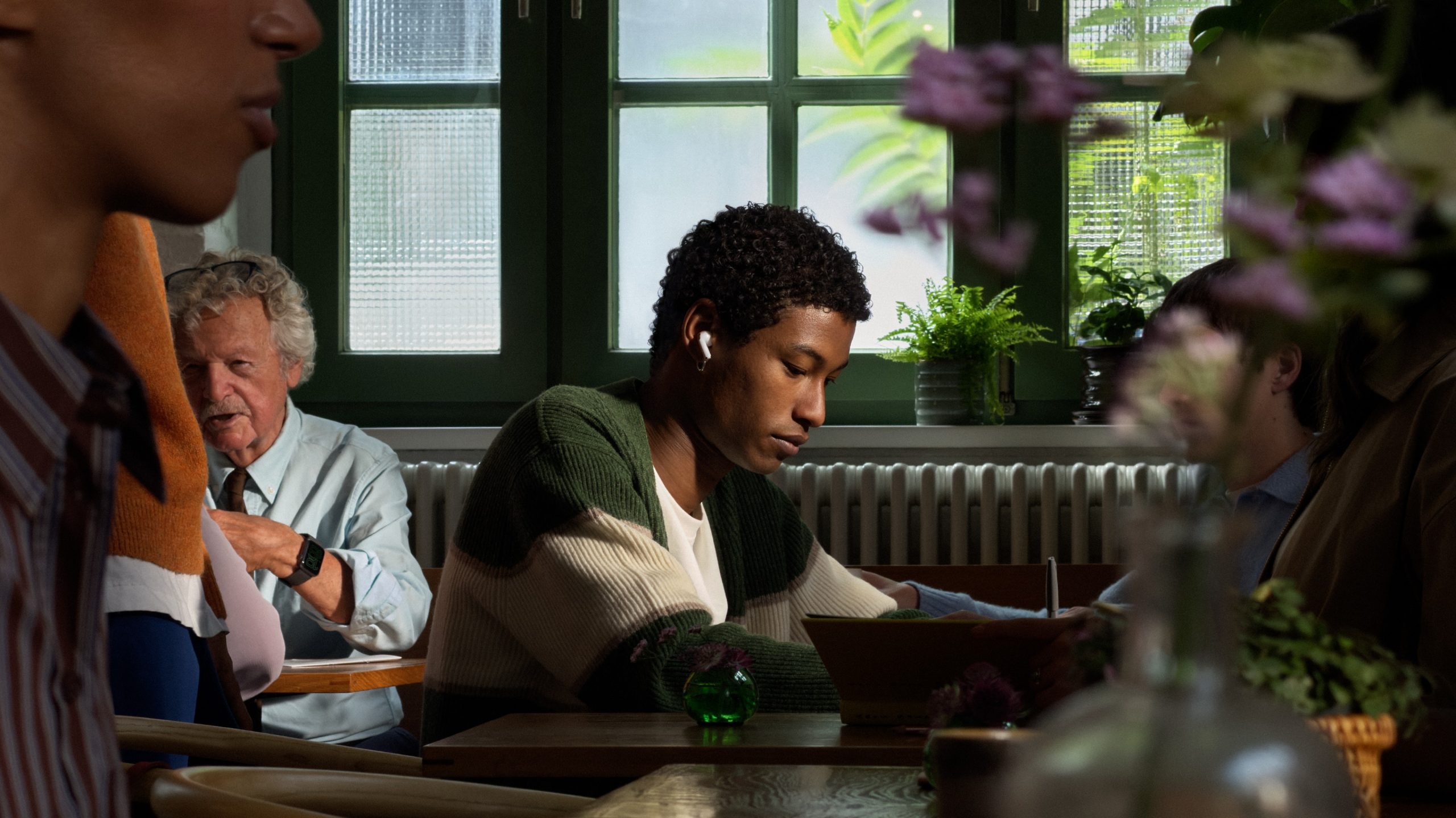 Una persona usando AirPods 5 mientras trabaja en un restaurante
